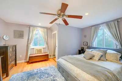 a bedroom with a bed and a ceiling fan at Cozy Dix Hills Apt with Deck about 7 Mi to Beach! in Dix Hills