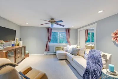 a living room with a couch and a tv at Cozy Dix Hills Apt with Deck about 7 Mi to Beach! in Dix Hills