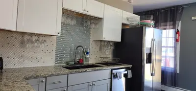a kitchen with white cabinets and a black refrigerator at Heavenly Home in New Haven in New Haven