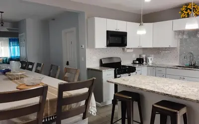 a kitchen with white cabinets and a table and chairs at Heavenly Home in New Haven in New Haven