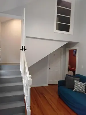 a white staircase in a living room with a blue couch at Heavenly Home in New Haven in New Haven