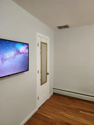 an empty room with a flat screen tv on a wall at Heavenly Home in New Haven in New Haven