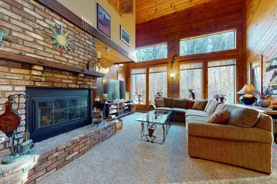 a living room with a fireplace and a stone wall at Suntec Getaway in Dover