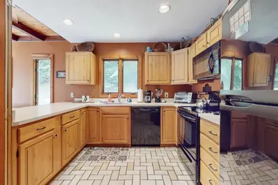 a large kitchen with wooden cabinets and appliances at Suntec Getaway in Dover