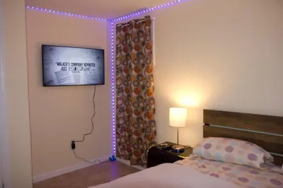 a bedroom with a bed and a tv and lights at Mamas Love 2bedroom Spacious Apartment in Newark