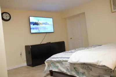 a bedroom with a bed and a tv on the wall at Mamas Love 2bedroom Spacious Apartment in Newark