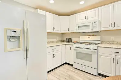 a kitchen with white cabinets and white appliances at Charming Beacon Apt with Fire Pit Near Hiking! in Beacon