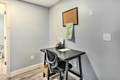 a black desk in a room with a chair at Charming Beacon Apt with Fire Pit Near Hiking! in Beacon