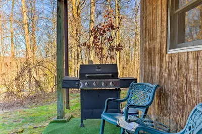 a grill with two chairs next to a house at Charming Beacon Apt with Fire Pit Near Hiking! in Beacon