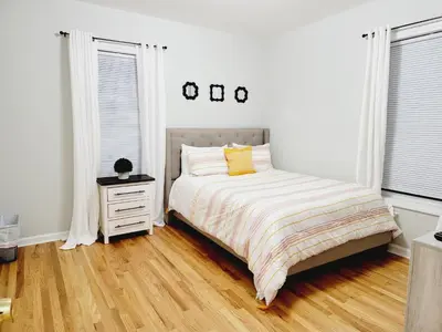 a white bedroom with a bed and a night stand at Room for rent in apartment Hartford, CT in Hartford