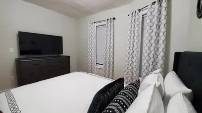 a bedroom with a white bed and a television at Room for rent in apartment Hartford, CT in Hartford