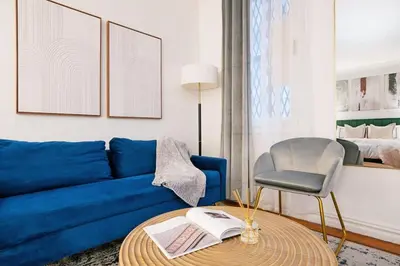 a living room with a blue couch and a chair at 105-1G Park Ave Location studio best value Sleeps3 in New York