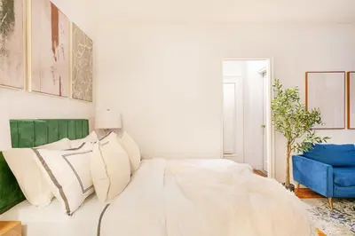 a bedroom with a white bed and a blue chair at 105-1G Park Ave Location studio best value Sleeps3 in New York