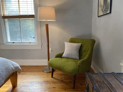 a bedroom with a green chair and a lamp at Howland House in Mount Tremper