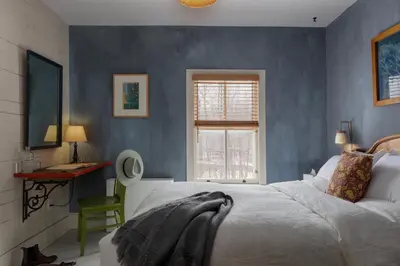 a bedroom with a bed and a desk and a window at Howland House in Mount Tremper