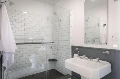 a white bathroom with a sink and a shower at Howland House in Mount Tremper