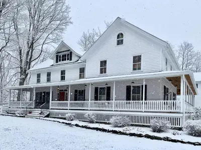 a large white house with snow on the ground at Howland House in Mount Tremper