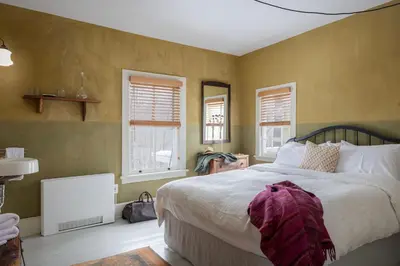 a bedroom with a large bed and two windows at Howland House in Mount Tremper