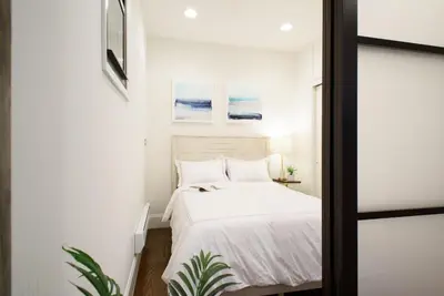 a bedroom with a bed with white sheets at 69-2B Prime Lower East East BRAND NEW 1br Apt in New York