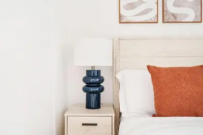a blue lamp sitting on a night stand next to a bed at 69-2C Brand New PRIME Lower East Side 1br Apt in New York