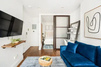 a living room with a blue couch and a tv at 69-3A Prime LES Modern Brand New 1BR in New York