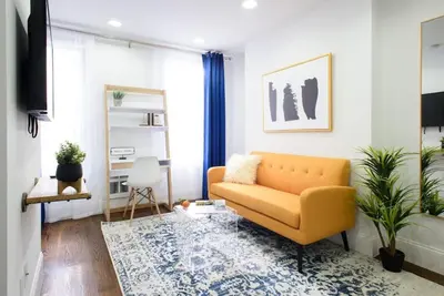 a living room with a yellow couch and a rug at 69-3B Prime Lower East Side BRAND NEW 1br Apt in New York