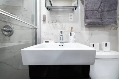 a white bathroom with a sink and a toilet at 69-3C Stylish Lower East East 1br Apt BRAND NEW in New York