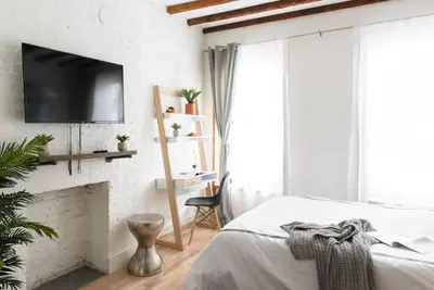 a bedroom with a tv on a white brick wall at 24-14 Renovated studio Prime gramercy W D in New York
