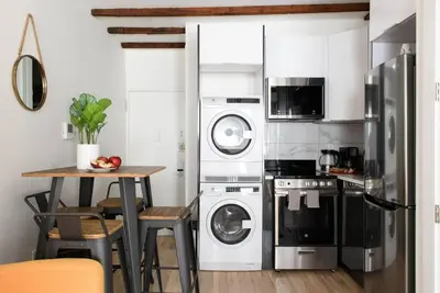 a kitchen with a washer and dryer and a table at 24-14 Renovated studio Prime gramercy W D in New York