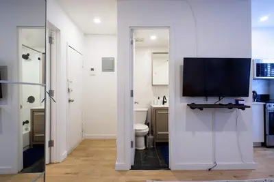 a bathroom with a toilet and a tv on a wall at 69-3D Prime Lower East East BRAND NEW 1br Apt in New York