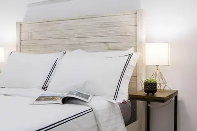 a bed with white sheets and a book on it at 69-3D Prime Lower East East BRAND NEW 1br Apt in New York