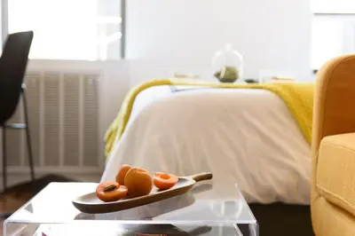 a table with two hot dogs on a plate on a bed at 24-16 Studio Gramercy W D gramercy in New York