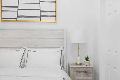a bedroom with a bed and a lamp on a night stand at 69-4B Modern Lower East Side 1BR PRIME LOCATION in New York