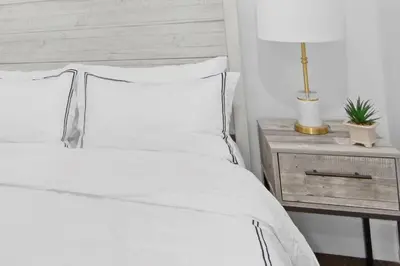 a bedroom with a white bed and a table with a lamp at 69-4B Modern Lower East Side 1BR PRIME LOCATION in New York