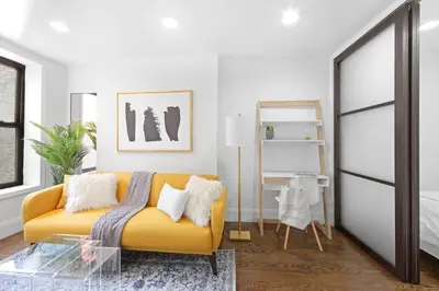 a living room with a yellow couch and a bed at 69-4B Modern Lower East Side 1BR PRIME LOCATION in New York