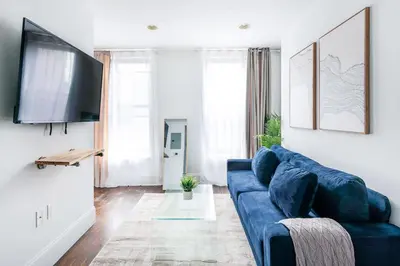 a living room with a blue couch and a tv at 69-5B I Stylish Lower East Side 1BR Apt BRAND NEW in New York