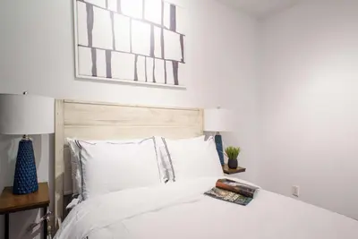 a bedroom with a white bed with a wooden headboard at 69-5D Modern Lower East East 1br Apt BRAND NEW in New York