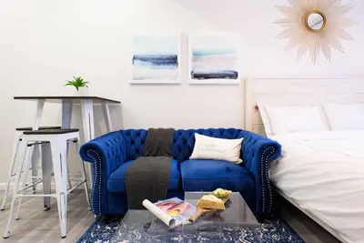 a living room with a blue couch and a bed at 240-11 NEW STUDIO Prime Upper East W&D in New York