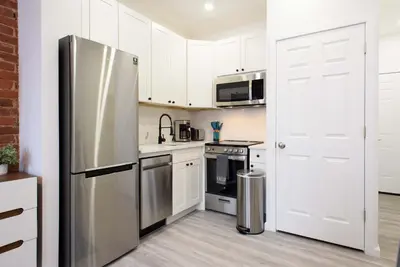 a kitchen with white cabinets and a stainless steel refrigerator at 240-11 NEW STUDIO Prime Upper East W&D in New York