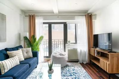 a living room with a blue couch and a tv at 809-3A 1BR Columbus Circle Elevator W D in New York
