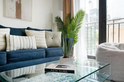a living room with a blue couch and a glass table at 809-3A 1BR Columbus Circle Elevator W D in New York