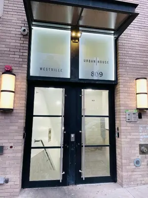 a store front with glass doors on a brick building at 809-3A 1BR Columbus Circle Elevator W D in New York