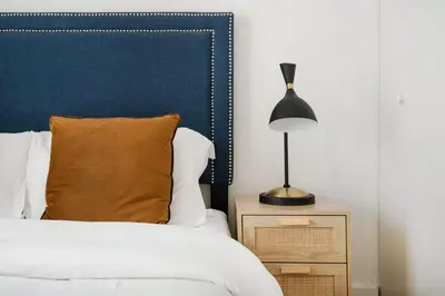 a bedroom with a bed with a blue headboard and a lamp at 809-4A Columbus Circle New BLDG 1BR W D in New York