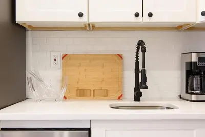 a kitchen counter with a sink and a cutting board at 240-14 NEW Studio Prime Location W&D in unit in New York