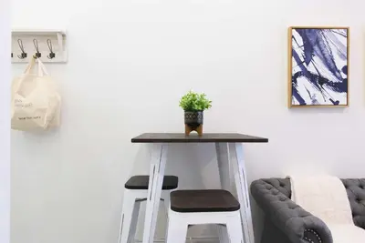 a table with two stools in a living room at 240-14 NEW Studio Prime Location W&D in unit in New York