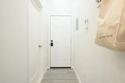 a hallway with a white door and a paper bag at 240-14 NEW Studio Prime Location W&D in unit in New York