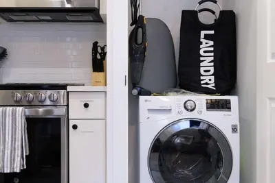 a kitchen with a washing machine and a bag at 240-14 NEW Studio Prime Location W&D in unit in New York
