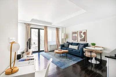a living room with a blue couch and a table at 809-4B Studio Balcony W D Prime location in New York
