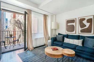 a living room with a blue couch and a table at 809-4B Studio Balcony W D Prime location in New York