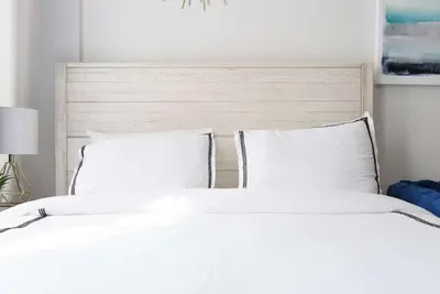 a white bed with white sheets and pillows at 240-15 Luxury Studio Prime Location W&D in New York